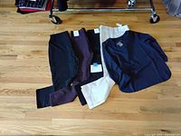 Four pairs of pants (leggings, chinos, khakis) and one navy JJill top arranged on floor
