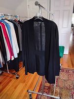 Black LL Bean cashmere sweater open-front on hanger in room