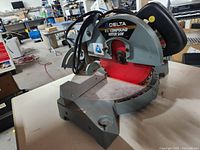 Full side view of the Delta compound miter saw showing the blade, base, handle and motor