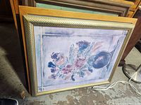 Framed floral artwork piece with gold-toned ornate inner frame and light wood outer frame