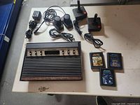 Overall lot contents including Atari console, two joysticks, 3 game cartridges and power adapter