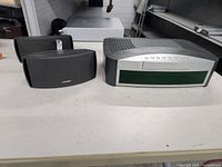 Bose Media Center main unit with two Bose speakers on a table.