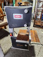 Front view of Craftsman 10 inch band saw showing the full saw with rust on metal worktable surface and base.