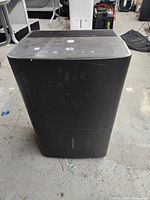 Front view of black GE dehumidifier showing control panel on top with digital humidity display reading 25.