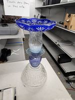 Full view of assembled glass birdbath showing the combination of blue cut glass basin, clear ribbed midsection, and clear textured glass base.