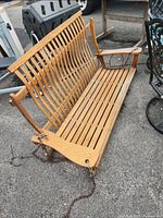Wooden hanging porch bench showing full length and chain attachments for hanging.
