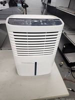 Front view of white Hisense dehumidifier showing air vents and water collection bucket with level indicator.