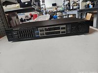 Front view of Kenwood Stereo Control Amplifier KC-105 on a white surface in a cluttered background.