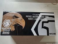 Box for the 1/24 scale Michael Waltrip Matco Tools Monte Carlo stock car diecast model. Black box with eagle graphic and numbering 1 of 3100.