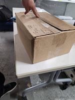 Closed cardboard box containing CDs