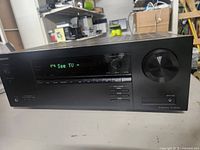 Front view of Onkyo TX-SR393 AV receiver powered on with display showing 'See TV'.