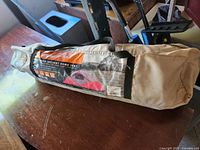 Tent in carry bag on wooden surface