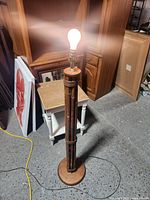 Full view of the lamp lit with visible light bulb on, showing overall structure and base.