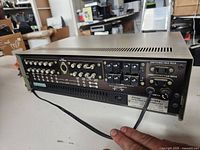 Rear view showing multiple RCA input/output jacks, speaker binding posts and power cord