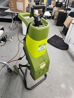 Front view of green and black Sunjoe electric wood chipper with handle and wheels.