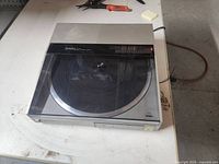 Turntable with dust cover closed showing powers on indicator light active