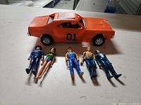 Orange General Lee toy car and six figures laid out