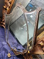 Full view of vintage mirror showing overall ornate curved frame design and mirror surface.