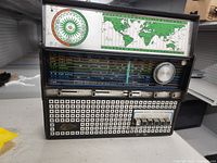 Front view of vintage radio showing tuning panel, world map, and time zone chart.