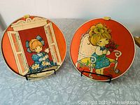 Both round Hallmark Charmer plaques front view