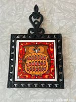 Front view showing entire cast iron frame and owl tile