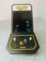 Front view of Coleco Pac-Man mini arcade game with screen and controls visible