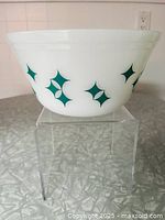 Side view showing intact turquoise Starburst graphics on white milk glass bowl