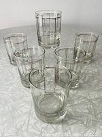 Six double old-fashioned glasses arranged on table showing the silver windowpane grid pattern