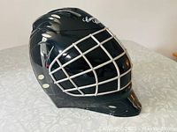 Black hockey goalie mask shaped promotional ice bucket with white face cage and Canadian Club logos.