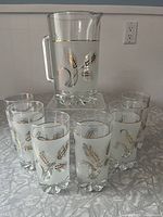 Full set includes six glasses and one pitcher displayed on table with white backdrop.