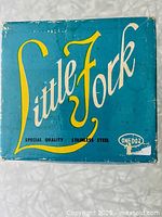 Blue Little Fork box with yellow and white 'Little Fork' branding and 'Special Quality Stainless Steel' tagline. Box is vintage with some wear.