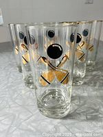 Set of six vintage bowling-themed glasses standing on a textured surface, showing the bowling ball and gold pins graphic on the front.