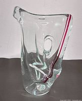 Front side view of clear art glass pitcher/vase showing integrated handle hole and pink stripe.