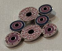 Close-up photo of pendant front showing oval shapes with pink crystals and purple enamel centers.