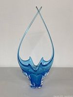 Full view of tall vintage blue hand blown art glass basket with crossed pointed tips