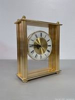Side view of the Seiko quartz mantle clock showing gold-tone frame with vertical ridges and glass panels.