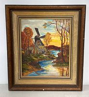 Full view of the framed vintage signed painting showing a river, windmill, houses, and autumn trees.