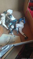 Three sports figures laid inside a cardboard box, showing positioning and details of each figure