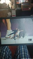 Framed image of figure skaters on ice focusing on their legs and posture.