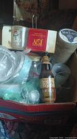 Top view inside the box showing various glasses, empty 1824 Amber beer bottle, coasters, candle, and jar.