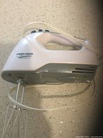 White Black & Decker PowerPro 250W hand mixer with two metal whisk attachments on a kitchen counter.