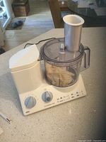 Braun CombiMax 800 electric food mixer with clear plastic mixing bowl and feeding chute on kitchen counter