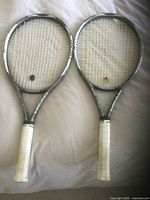 Two Head tennis rackets shown lying next to each other, displaying grips, strings and frames clearly for evaluation.