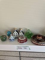 Full view of all collectable home decor items including Delft pieces, cloisonné apple box, blown glass basket, bowls, and Limoges dish.