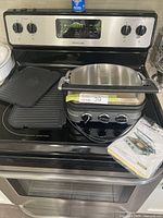 Cuisinart Griddler unit on stovetop showing cooking plates and control dials.