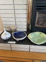 All four bowls displayed on a hearth in front of a fireplace.