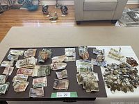 Overview of foreign paper bills and coins spread on table.
