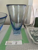 Front and side view of the blue blown glass vase with thick blue base and flared rim