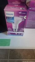 Box of Philips Ultra Dimmable LED 45W equivalent light bulb, white packaging with purple design.
