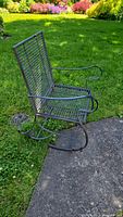 Side view of steel rocking chair on grass and concrete patio